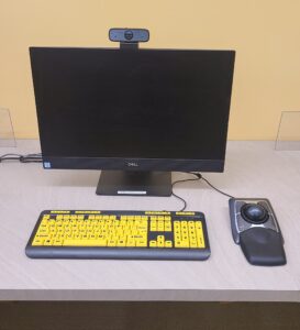 Accessible computer station with high-contrast, large print keyboard, trackball, and webcam.